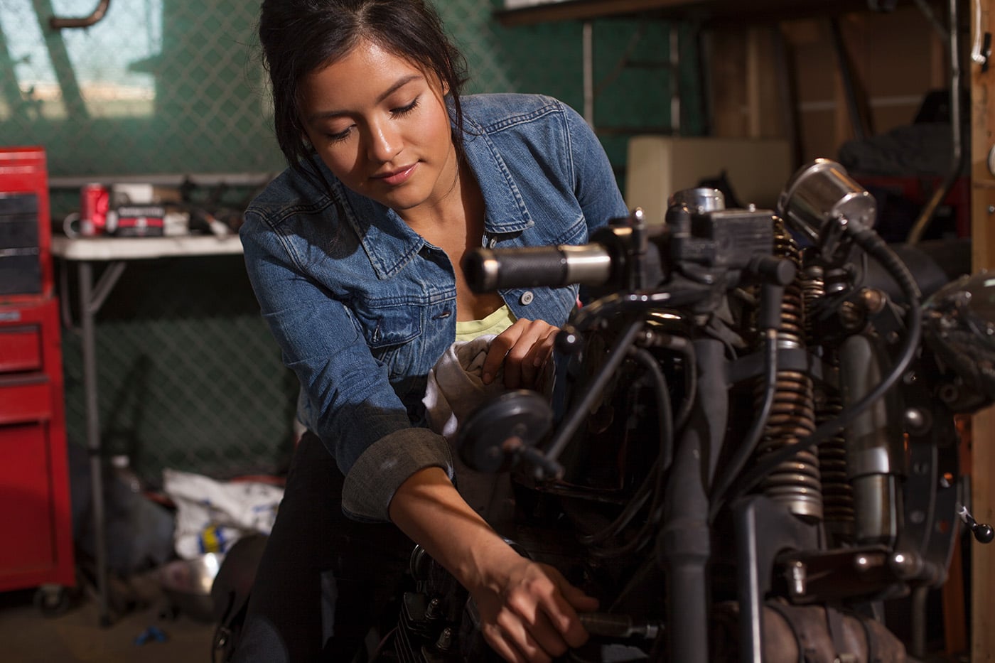 Female mechanic works on motorcycle