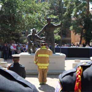 A firefighter honors a fallen friend at the America's Fallen Firefighter Memorial in Ogden UT