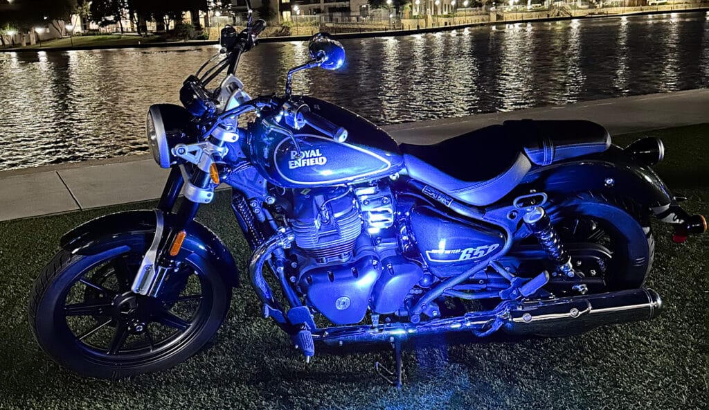 Royal Enfield 2023 Super Meteor 650 bathed in blue light near waterfront.