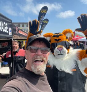 Noel Dobson of Motorcycle Man Transport and Storage poses with Law Tiger mascot