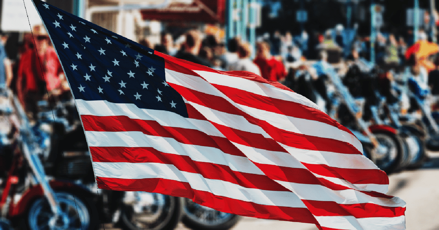 Photo of American flag with motorcycles in background