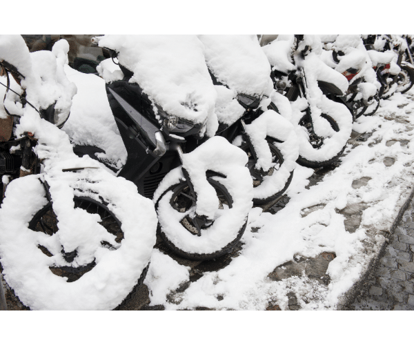 row of motorcycles covered in snow